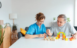 Professional nurse caregiver in memory care helps senior man with Alzheimer's disease